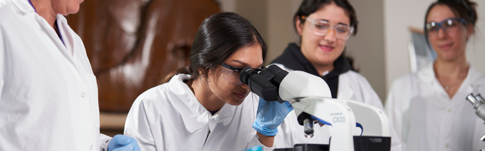 A science student looking through a microscope.